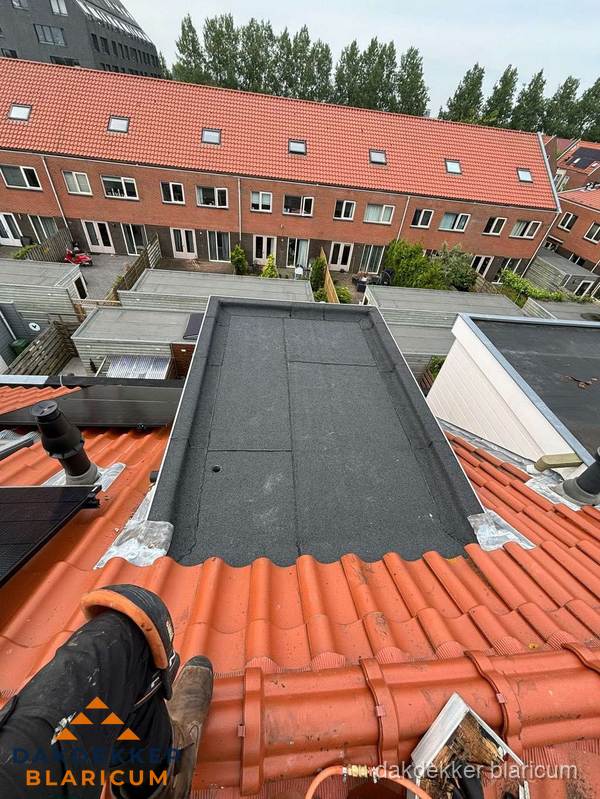 Bitumen dak reparatie op plat dak tussen dakpannen in Blaricum