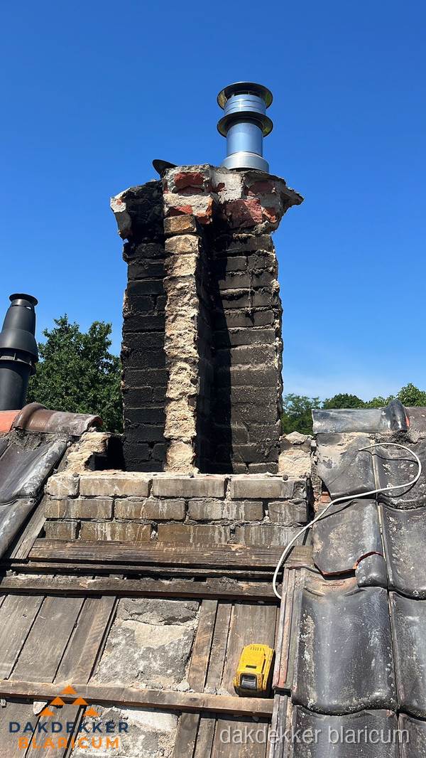 Beschadigde schoorsteen met nieuwe rookgasafvoer op oud dak in Blaricum Beschadigde schoorsteen met nieuwe rookgasafvoer op oud dak in Blaricum