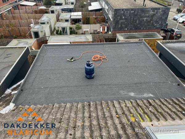 Plat dak met nieuwe bitumen dakbedekking en brandgereedschap in Blaricum