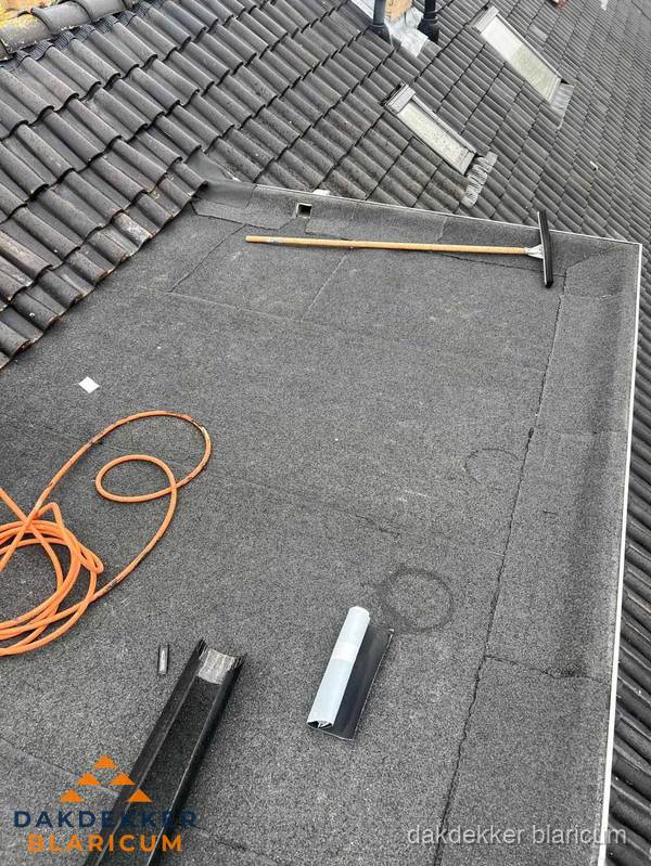Plat dak reparatie met gereedschap en loodstroken in Blaricum Plat dak reparatie met gereedschap en loodstroken in Blaricum