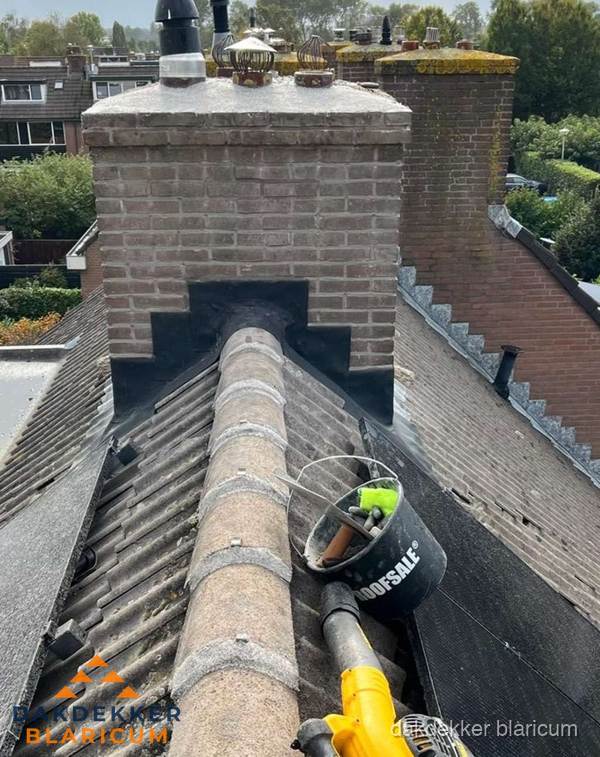 Schoorsteen met loodaansluiting en nokvorst op pannendak in Blaricum